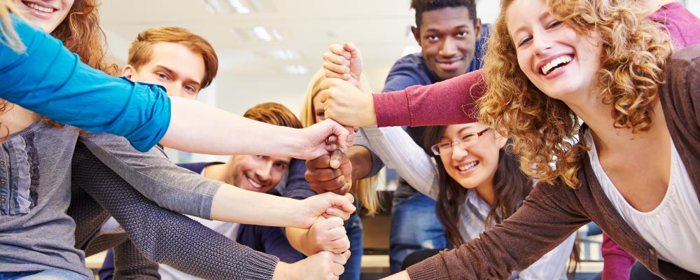 Group of people supportively stacking their fists